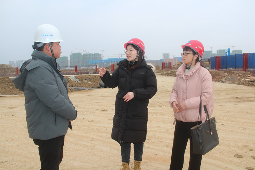 黃金蘭（中）在工地上察看企業(yè)建設進度.JPG