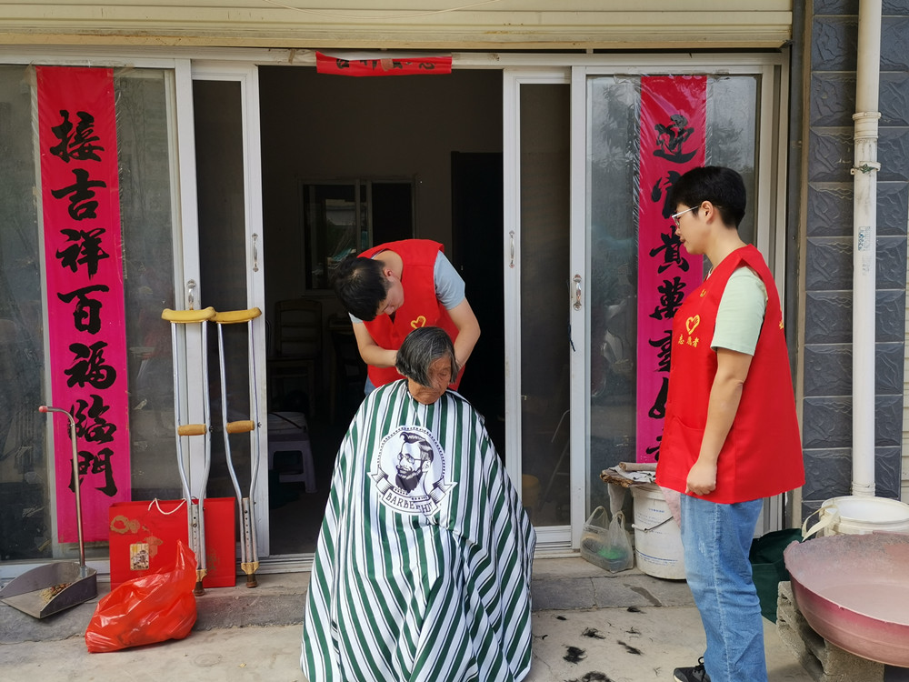 圖為理發(fā)師為江奶奶修剪頭發(fā)。.jpg