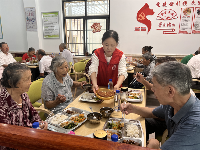 圖為志愿者為老人分發(fā)月餅。.png