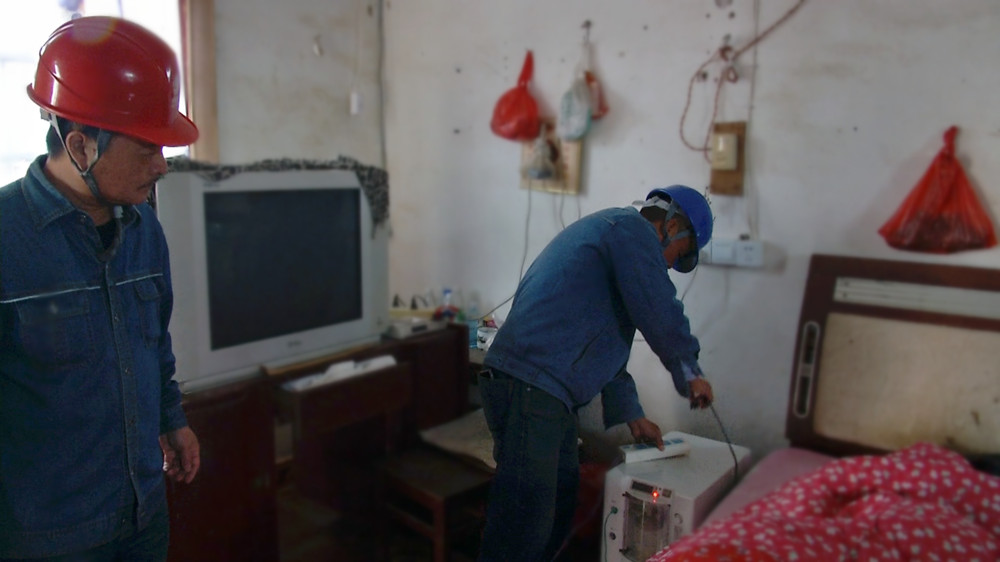 圖為呂亭中心供電所工作人員正在給江老老伴的呼吸機接通臨時電源.jpg