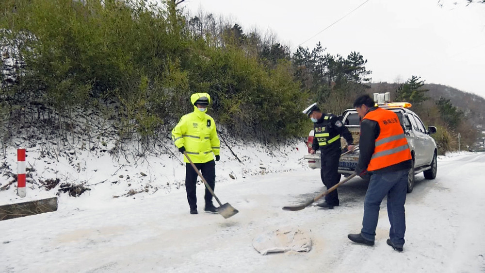 圖為交警和公路部門協(xié)作撒鹽融冰保暢通 拷貝.jpg