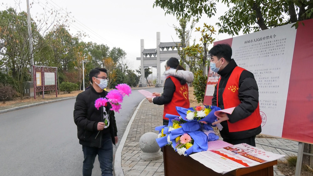 圖為志愿者正在對(duì)過往群眾進(jìn)行文明祭祀宣傳.jpg