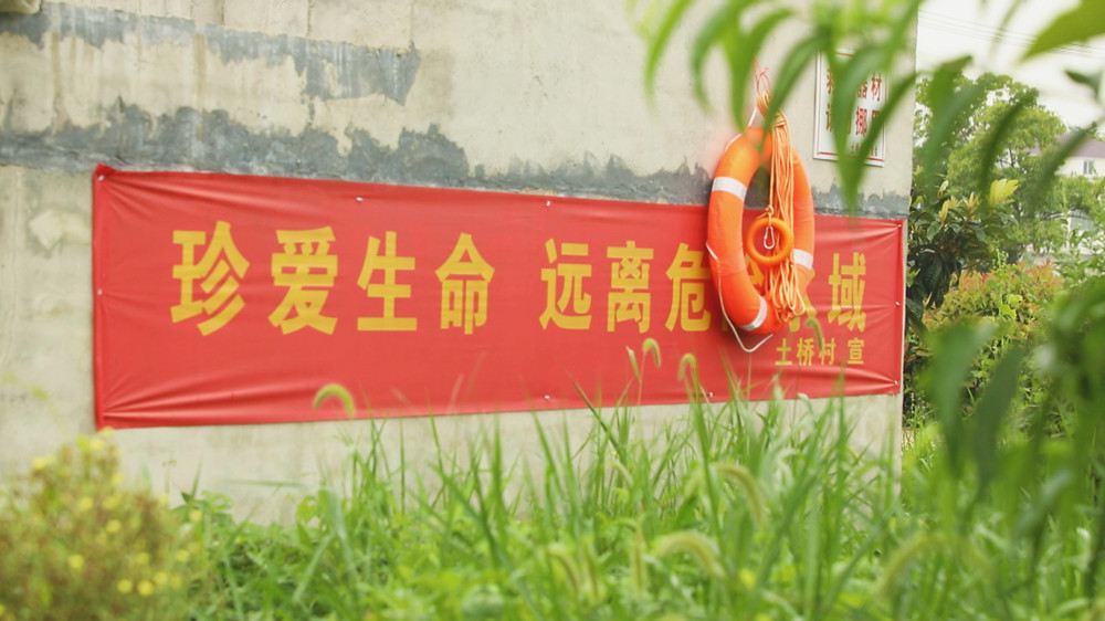 圖為土橋村設(shè)置的防溺水宣傳標語和防溺水物資 .jpg