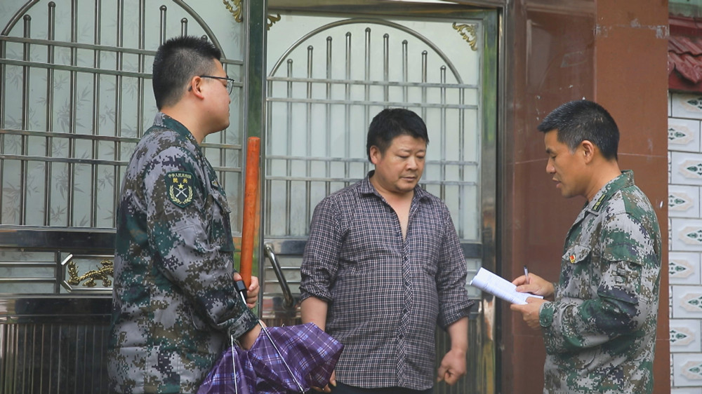 圖為當?shù)匮膊殛爢T正在走村串戶進行巡查隱患點和宣傳安全防范知識1.jpg