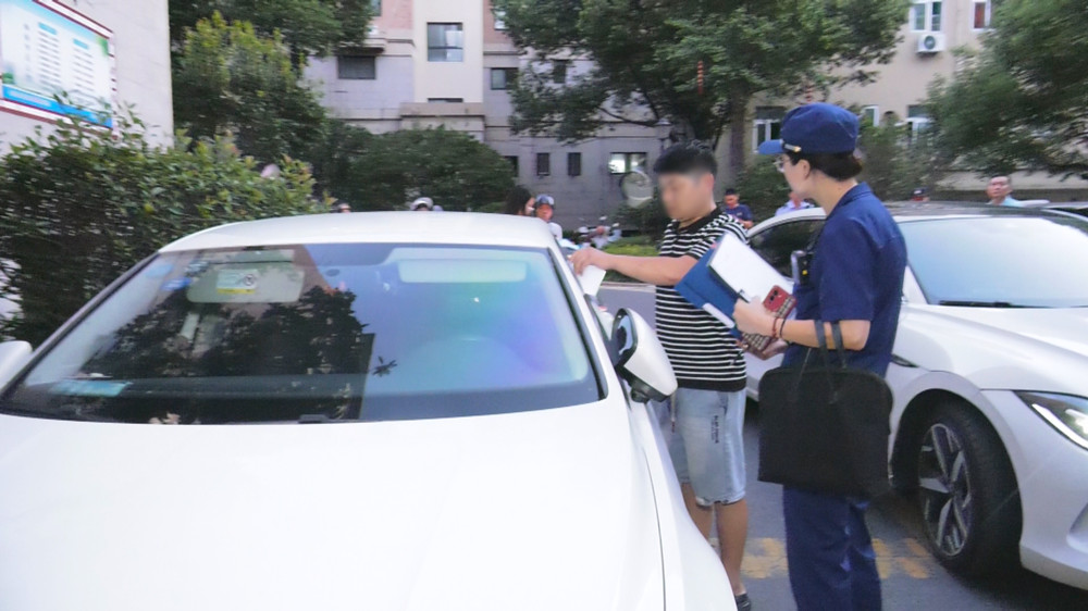 圖為檢查人員正在對(duì)一占用消防通道車(chē)主進(jìn)行教育警告.jpg