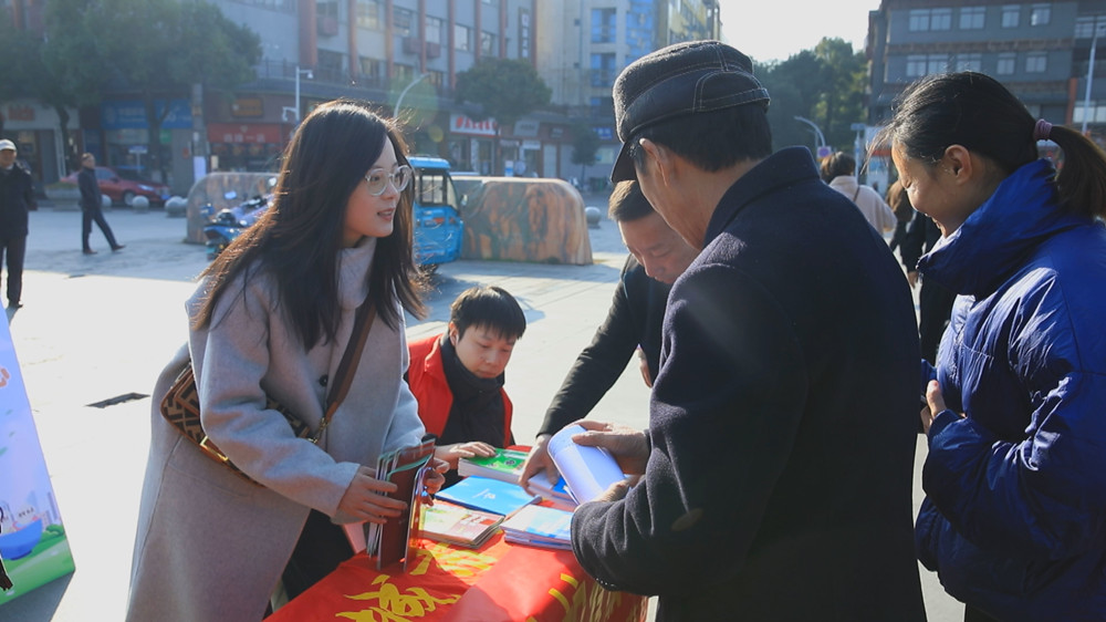 圖為工作人員正在為過往群眾發(fā)放宣傳材料，并答疑解惑。.jpg