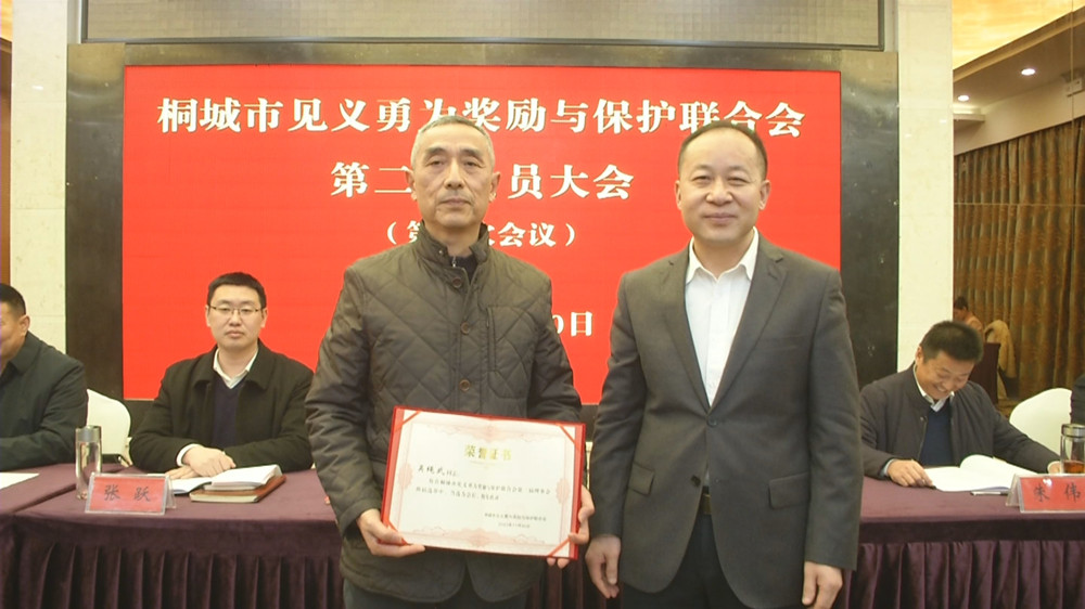 圖為市委常委、政法委書記為新當(dāng)選的桐城市第二屆見義勇為余保護(hù)聯(lián)合會(huì)會(huì)長吳繩武頒發(fā)任命證書.jpg