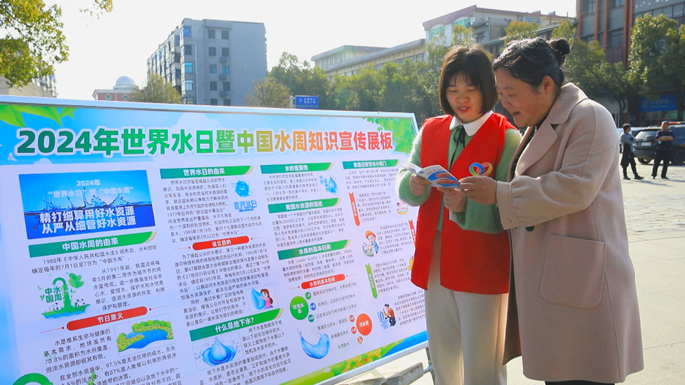 圖為現(xiàn)場(chǎng)工作人員正在給過往市民普及節(jié)約用水知識(shí).jpg
