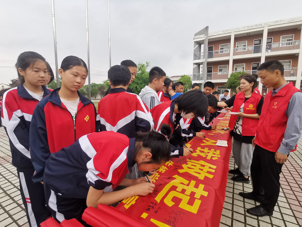 圖為朱橋?qū)W校學(xué)生在防溺水橫幅簽名時(shí)的情景2.jpg