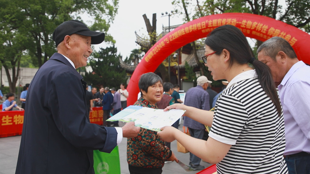 圖為現(xiàn)場工作人員正在向過往市民發(fā)放宣傳材料，講解生物多樣性知識。.jpg