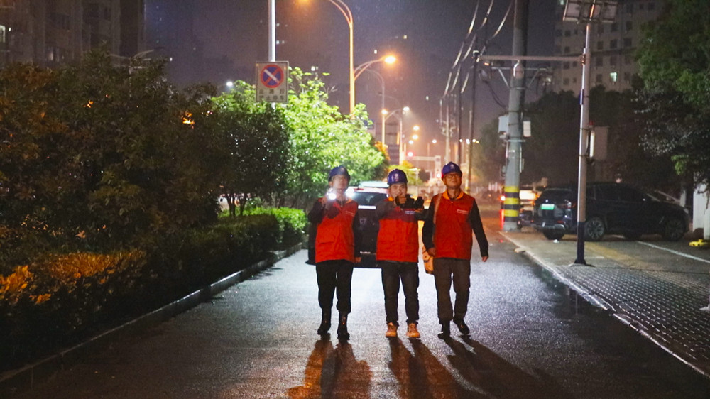 圖為國網(wǎng)桐城市供電公司工作人員正在實(shí)驗(yàn)中學(xué)考點(diǎn)外進(jìn)行用電線路夜巡工作.jpg
