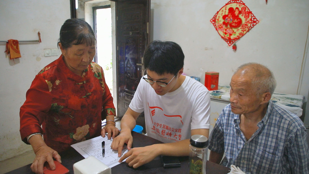 圖為安徽醫(yī)科大學(xué)暑期“三下鄉(xiāng)”社會實(shí)踐團(tuán)隊正在村民家長開展問卷調(diào)查1.jpg