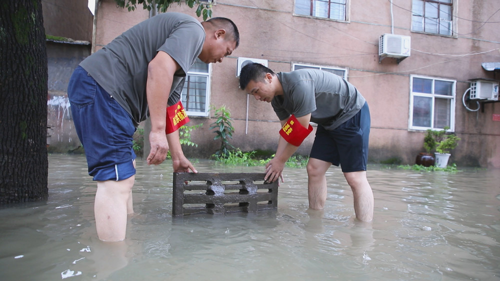 圖為雙港鎮(zhèn)退役軍人 基干民兵正在拉開窨井蓋緊急排水。.jpg