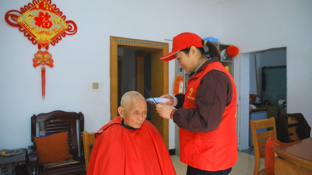 圖為龍眠街道南演社區(qū)志愿者正在為社區(qū)老人免費(fèi)理發(fā).jpg