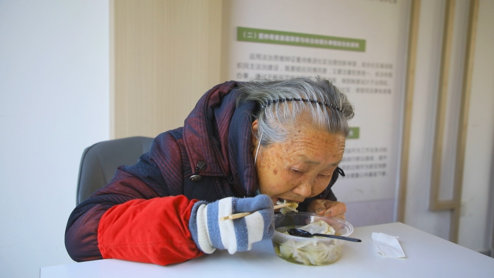圖為社區(qū)老人正在空調(diào)房里享受暖意融融的餃子.jpg