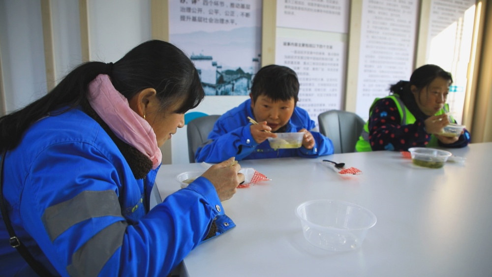 圖為環(huán)衛(wèi)工人正在空調(diào)房里享受暖意融融的餃子.jpg