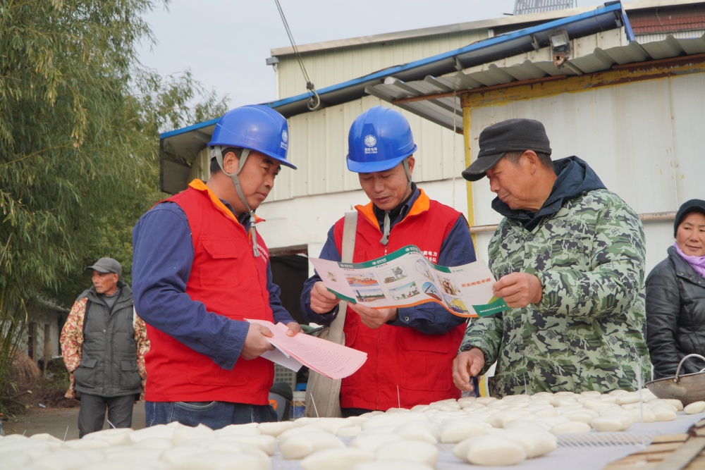 圖中工作人員向居民科普用電安全知識(shí).JPG