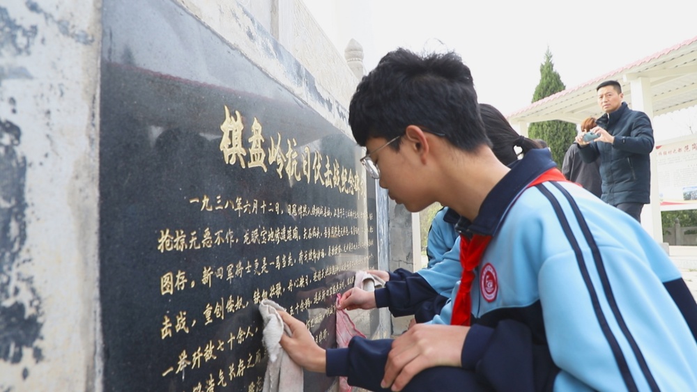 圖為參加活動的學(xué)生正在擦拭紀念碑1.jpg