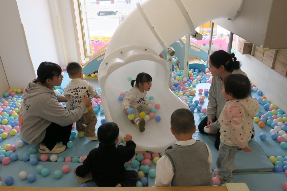 托育中心內(nèi)幼師和保育員帶著小朋友們?cè)谟螒騾^(qū)玩耍.JPG