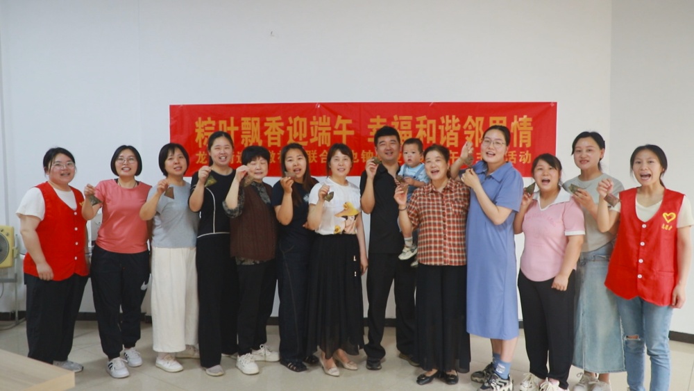 圖為參加活動人員展示自己包的粽子，并祝大家端午安康.jpg